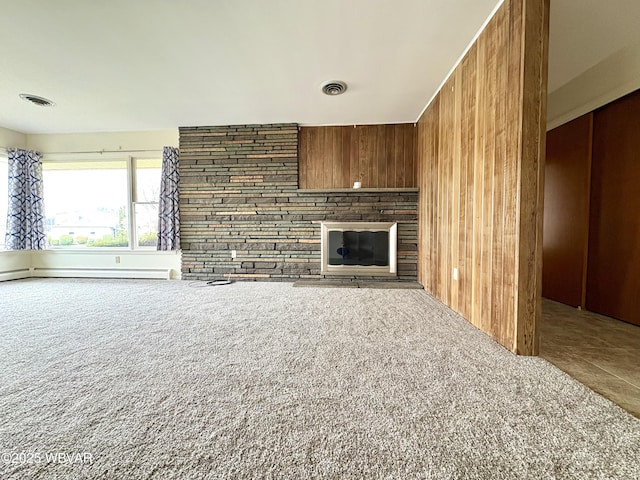 316 Winter St, Duboistown, PA 17702 - unfurnished living room featuring a baseboard heating unit, wooden walls, a large fireplace, carpet flooring, and visible vents