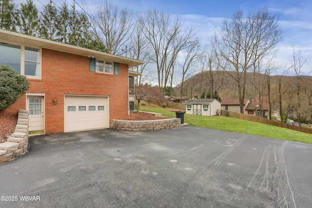 316 Winter St, Duboistown, PA 17702 - view of side of home with a storage unit, fence, a garage, a yard, and aphalt driveway