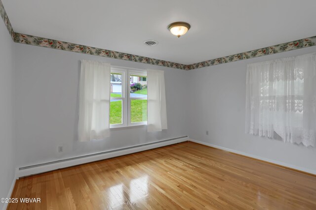 316 Winter St, Duboistown, PA 17702 - unfurnished room featuring a baseboard heating unit, wood finished floors, visible vents, and baseboards