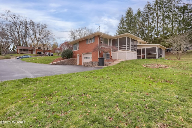 316 Winter St, Duboistown, PA 17702 - exterior space with aphalt driveway, an attached garage, brick siding, a sunroom, and a front yard