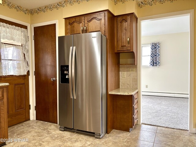 316 Winter St, Duboistown, PA 17702 - kitchen featuring light stone counters, a baseboard heating unit, brown cabinets, stainless steel fridge with ice dispenser, and backsplash