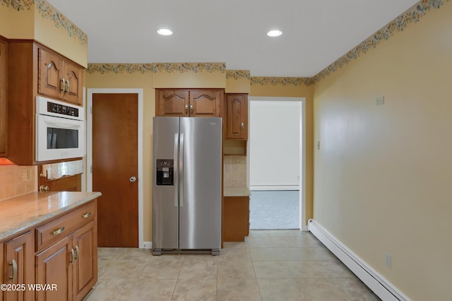 316 Winter St, Duboistown, PA 17702 - kitchen featuring white oven, decorative backsplash, brown cabinets, stainless steel refrigerator with ice dispenser, and a baseboard radiator