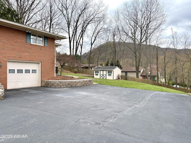 316 Winter St, Duboistown, PA 17702 - exterior space with an attached garage, fence, aphalt driveway, and an outdoor structure