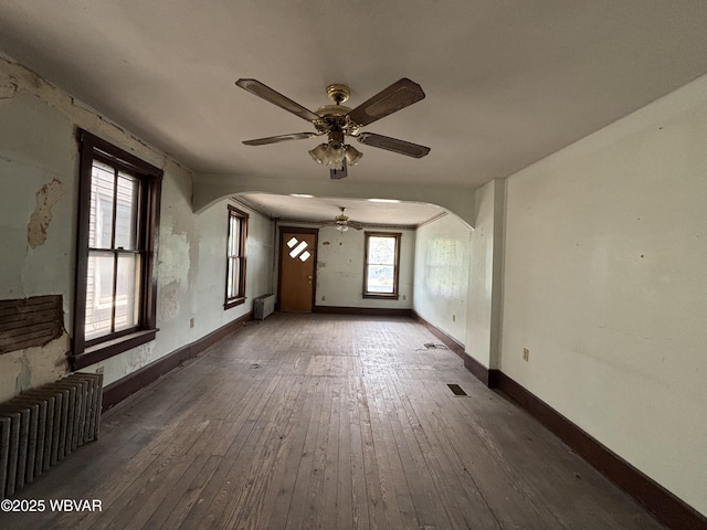 877-879 S 2nd St, Sunbury, PA 17801 - unfurnished living room with radiator, arched walkways, ceiling fan, and wood-type flooring