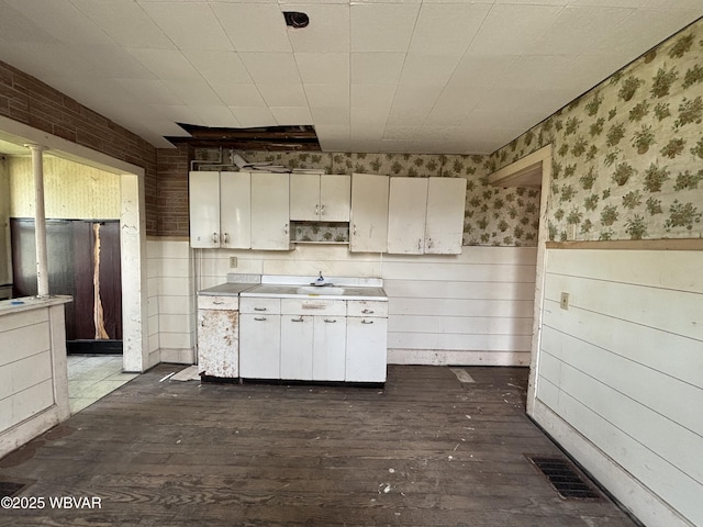 877-879 S 2nd St, Sunbury, PA 17801 - kitchen with dark wood finished floors, wainscoting, light countertops, and wallpapered walls