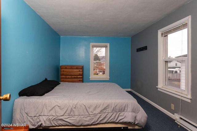 carpeted bedroom featuring baseboard heating