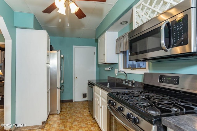 kitchen with white cabinets, appliances with stainless steel finishes, ceiling fan, and sink