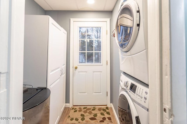 clothes washing area with stacked washer and dryer