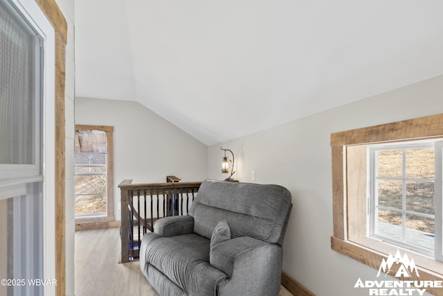 living area with light wood-style flooring and vaulted ceiling