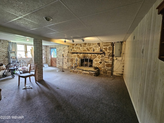 399 Sholder Rd, Williamsport, PA 17701 - carpeted living area with electric panel, wooden walls, rail lighting, a stone fireplace, and decorative columns