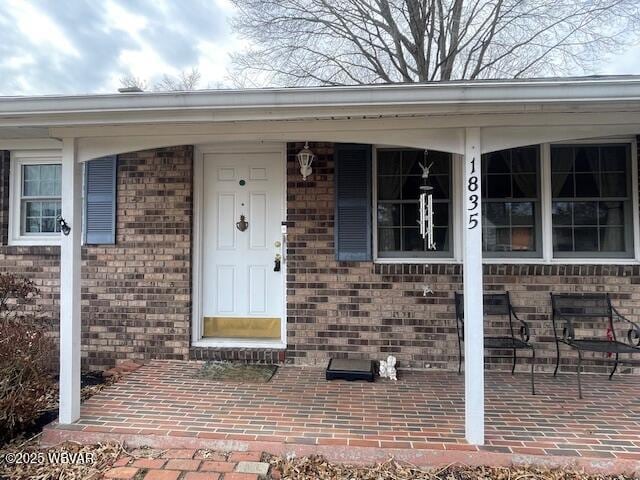 property entrance featuring brick siding