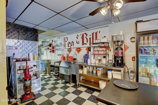 interior space with a drop ceiling and ceiling fan