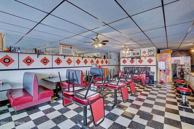 workout area featuring a wall mounted air conditioner, a paneled ceiling, and ceiling fan