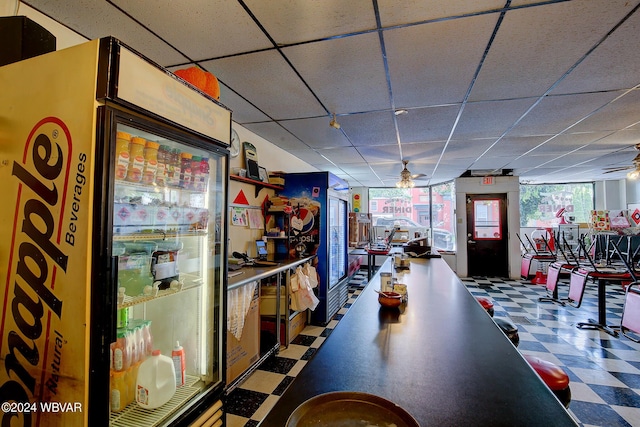 bar featuring a paneled ceiling, refrigerator, and ceiling fan