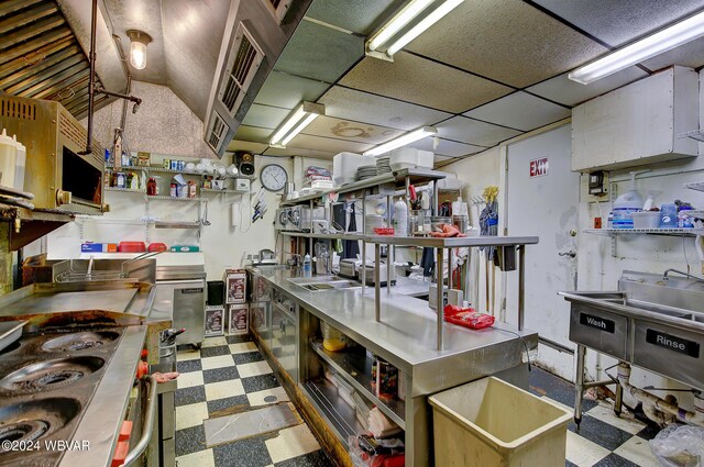 kitchen with a paneled ceiling and stainless steel counters