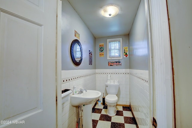 bathroom with toilet and tile walls