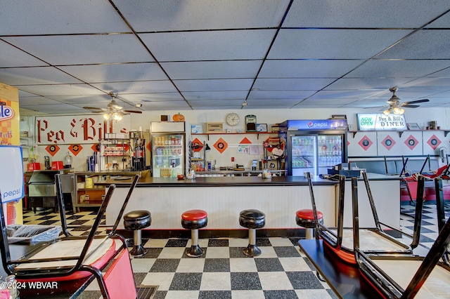 interior space with ceiling fan and a drop ceiling