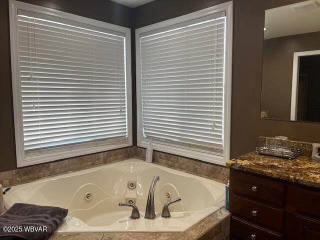 bathroom featuring vanity and a relaxing tiled tub