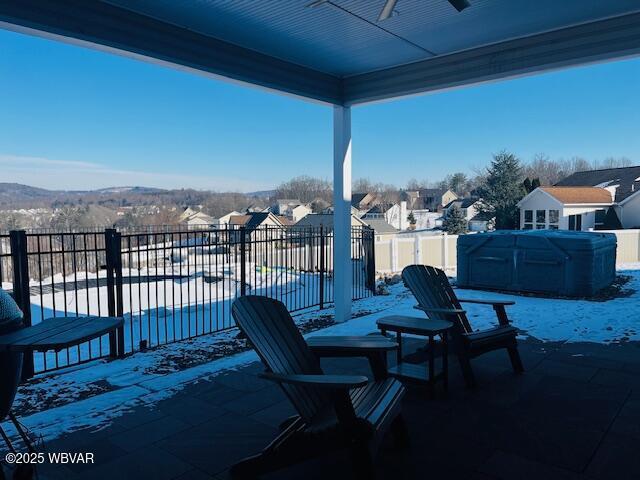 snow covered patio with ceiling fan and a pool