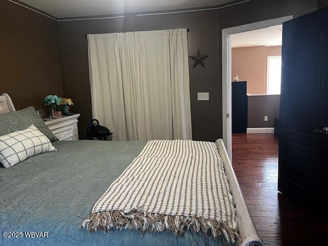 bedroom with dark hardwood / wood-style flooring