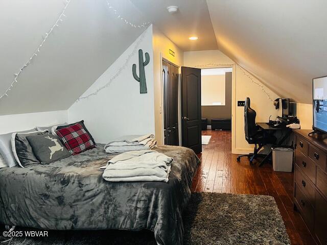 bedroom featuring lofted ceiling, a closet, and dark hardwood / wood-style floors