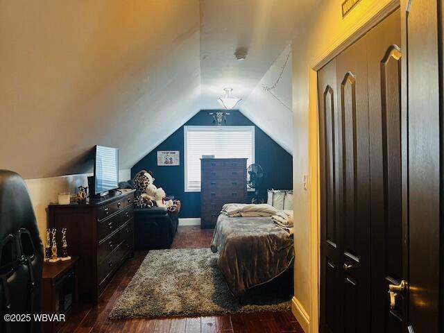 bedroom featuring lofted ceiling, dark wood-type flooring, and a closet