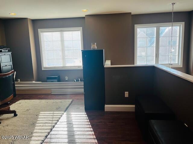 home office with a healthy amount of sunlight and dark hardwood / wood-style floors