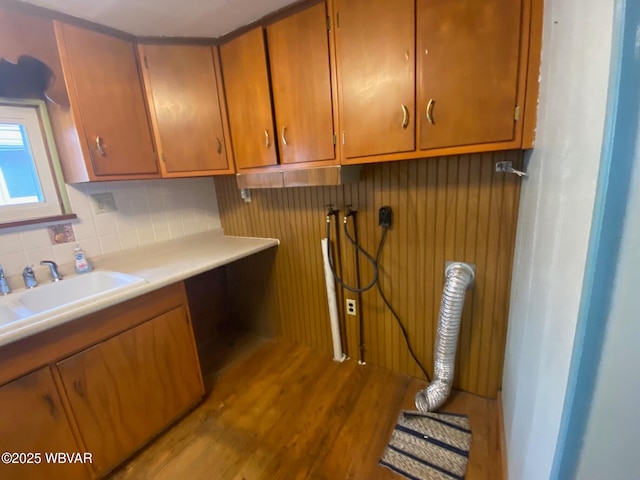 laundry area with sink, light hardwood / wood-style flooring, and cabinets