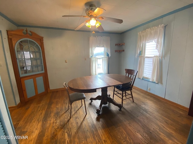 dining room featuring crown molding, dark wood-type flooring, and ceiling fan