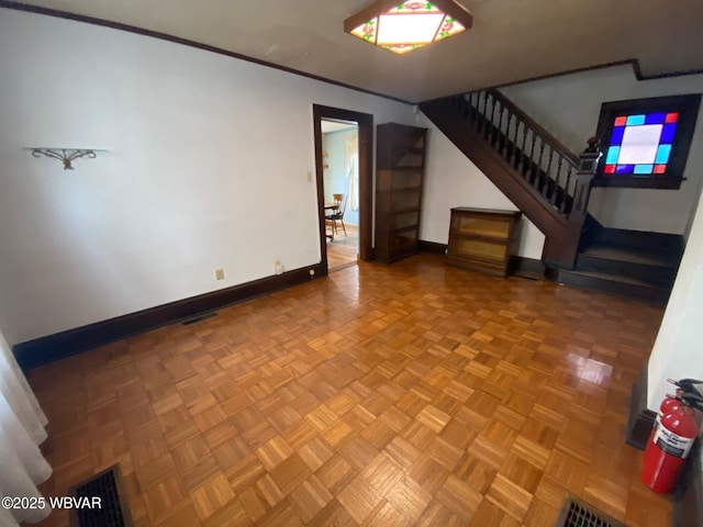 unfurnished living room with crown molding and parquet floors