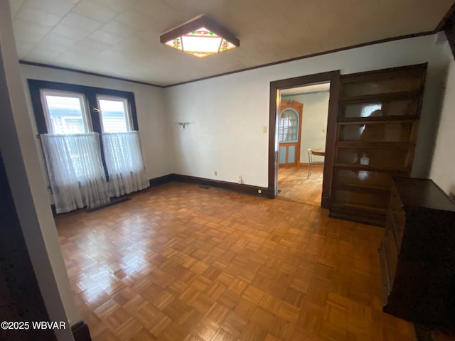 empty room featuring crown molding and light parquet flooring