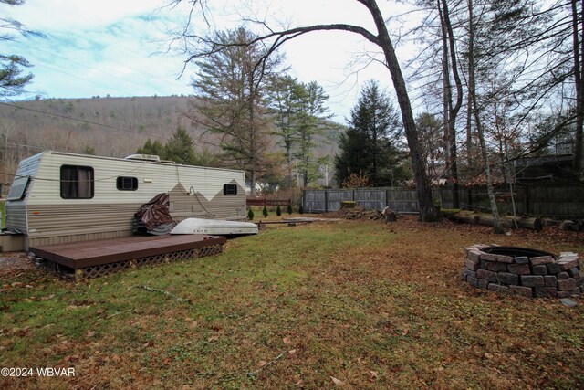 view of yard featuring an outdoor fire pit and a deck