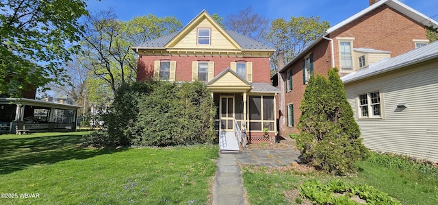 view of front of property with a front lawn, a sunroom, and metal roof
