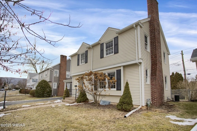 view of front of property with a front yard and central air condition unit