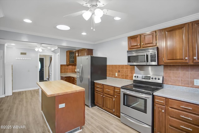 kitchen featuring butcher block countertops, ceiling fan, stainless steel appliances, light hardwood / wood-style floors, and a kitchen island