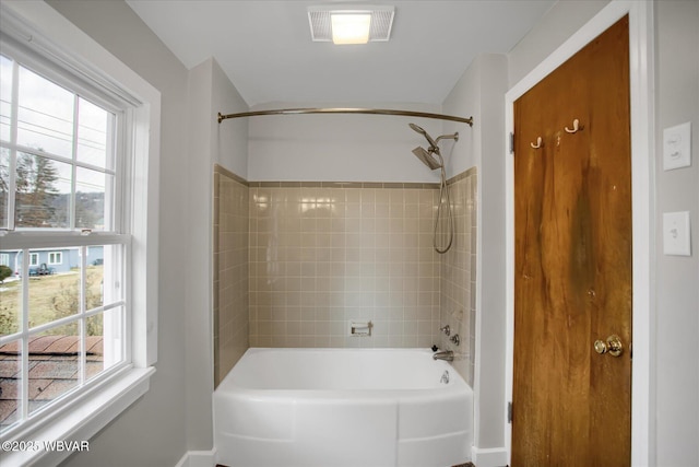 bathroom with tiled shower / bath combo and a wealth of natural light