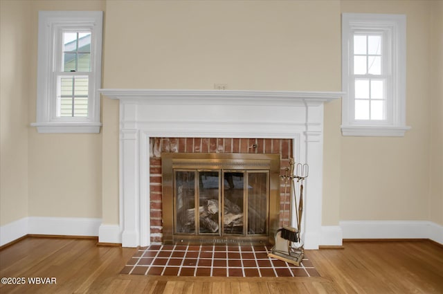 details featuring hardwood / wood-style flooring and a brick fireplace