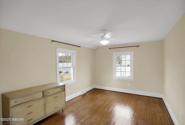 unfurnished room with ceiling fan, a healthy amount of sunlight, and light hardwood / wood-style floors