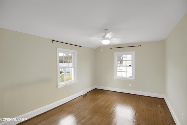 unfurnished room with hardwood / wood-style floors, a wealth of natural light, and ceiling fan