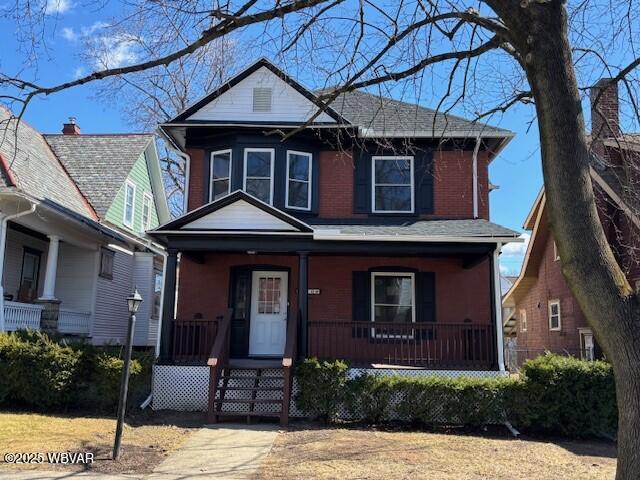 american foursquare style home with a porch