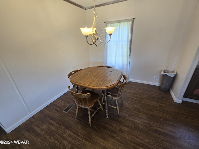 dining room featuring crown molding, dark hardwood / wood-style flooring, and an inviting chandelier