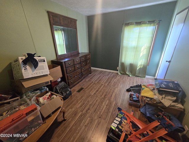 bedroom featuring hardwood / wood-style floors and a textured ceiling