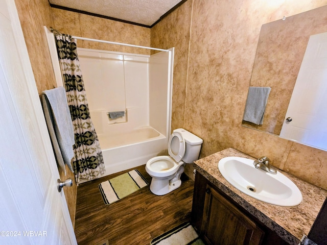 full bathroom featuring vanity, toilet, a textured ceiling, shower / tub combo with curtain, and wood-type flooring