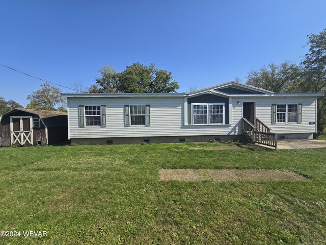 view of front facade featuring a front yard and a storage unit