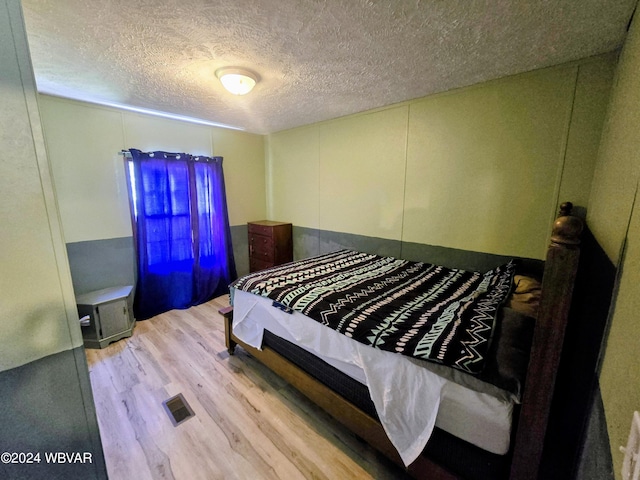 bedroom featuring hardwood / wood-style floors and a textured ceiling