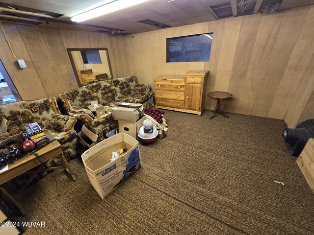 living room with dark carpet and wood walls