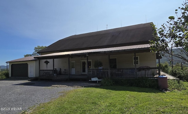 view of front of property featuring a front lawn, covered porch, and a garage