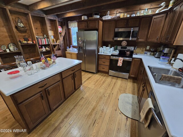 kitchen with dark brown cabinets, light hardwood / wood-style floors, sink, and appliances with stainless steel finishes