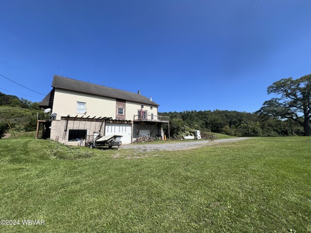 exterior space featuring a lawn, a garage, and a wooden deck