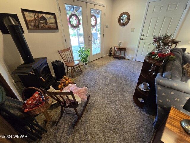 living area with carpet, french doors, and a wood stove